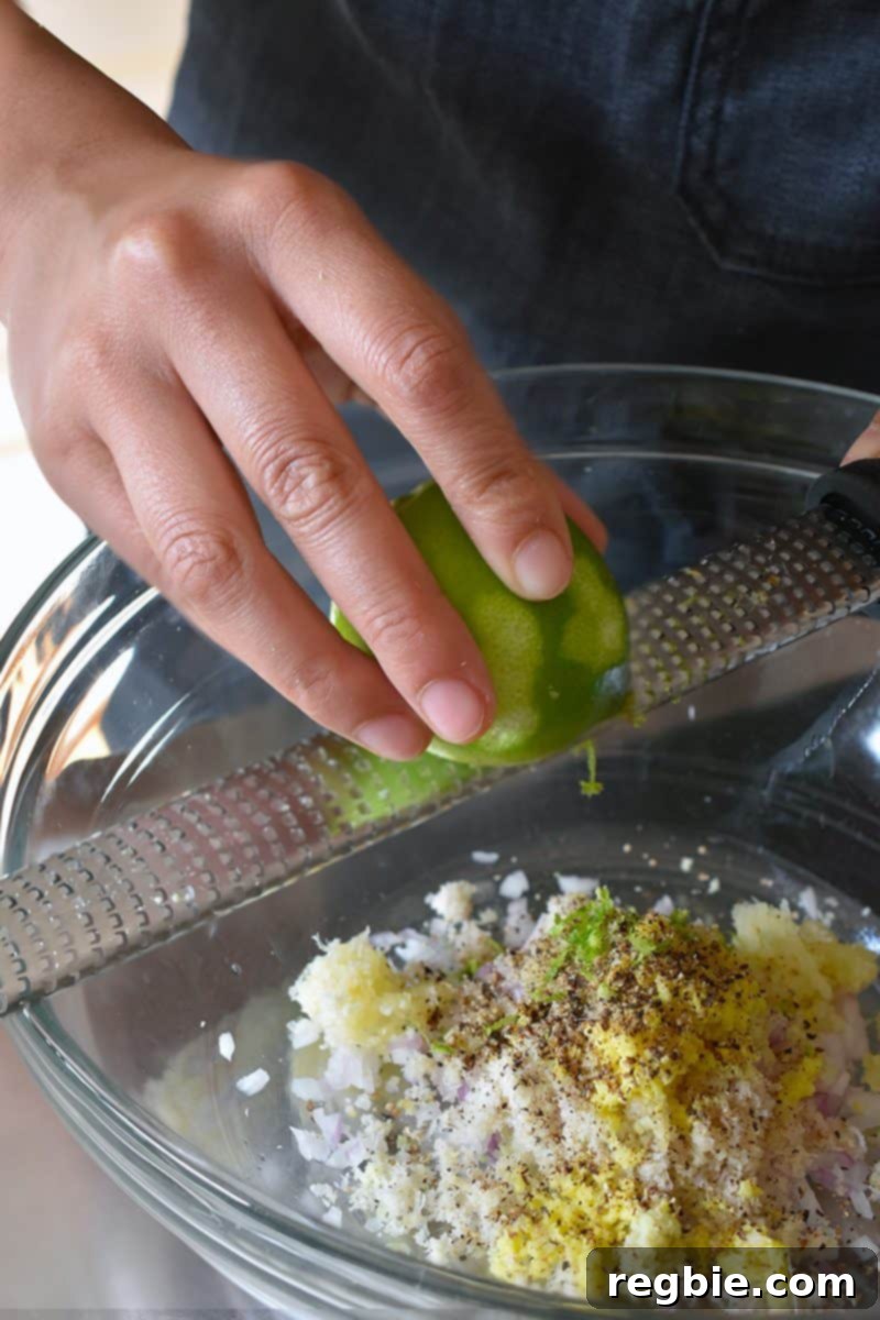 Zesting a fresh lime directly into the bowl for the Vietnamese Lemongrass Chicken marinade, ensuring no bitter pith is included.