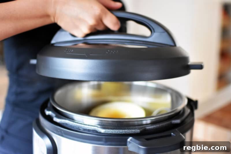 Quick Foolproof Instant Pot Spaghetti Squash 10 A close-up of an Instant Pot lid being carefully lowered into position to seal the pressure cooker and begin the cooking process for spaghetti squash.