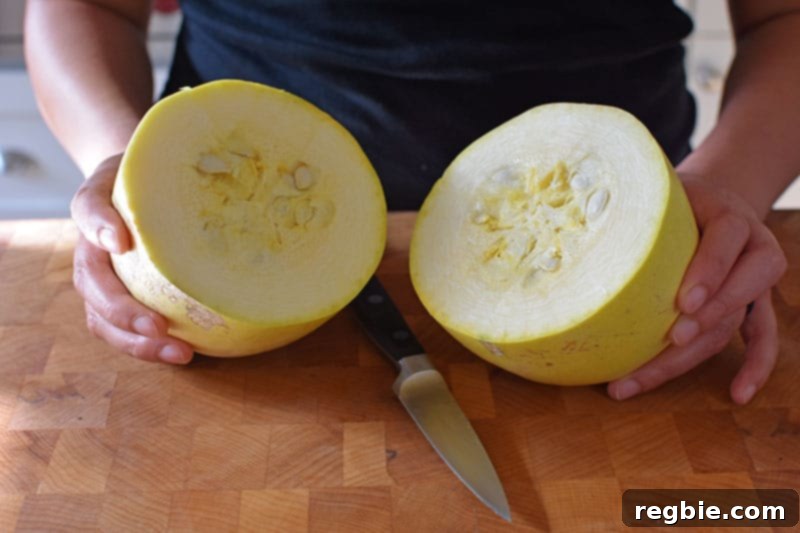 Quick Foolproof Instant Pot Spaghetti Squash 6 A spaghetti squash clearly cut in half horizontally with a small paring knife, revealing the circular pattern of its internal strands and demonstrating the benefits of crosswise cutting.