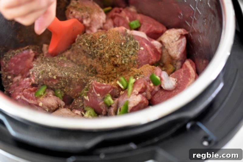 Stirring the ingredients for Instant Pot Spicy Pineapple Pork with a silicone spatula.