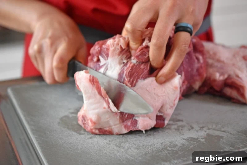 Trimming the fat off of a pork shoulder roast to make pineapple pork stew.