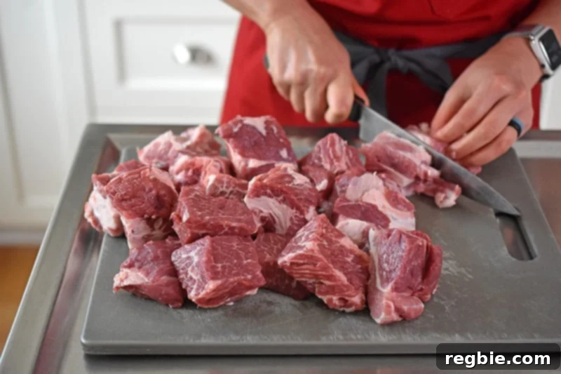 Cutting pork shoulder roast into cubes for Pineapple Pork Stew.