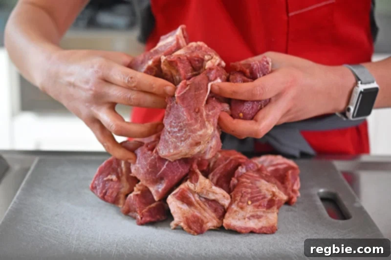 Tossing the pork shoulder cubes with Magic Mushroom Powder.