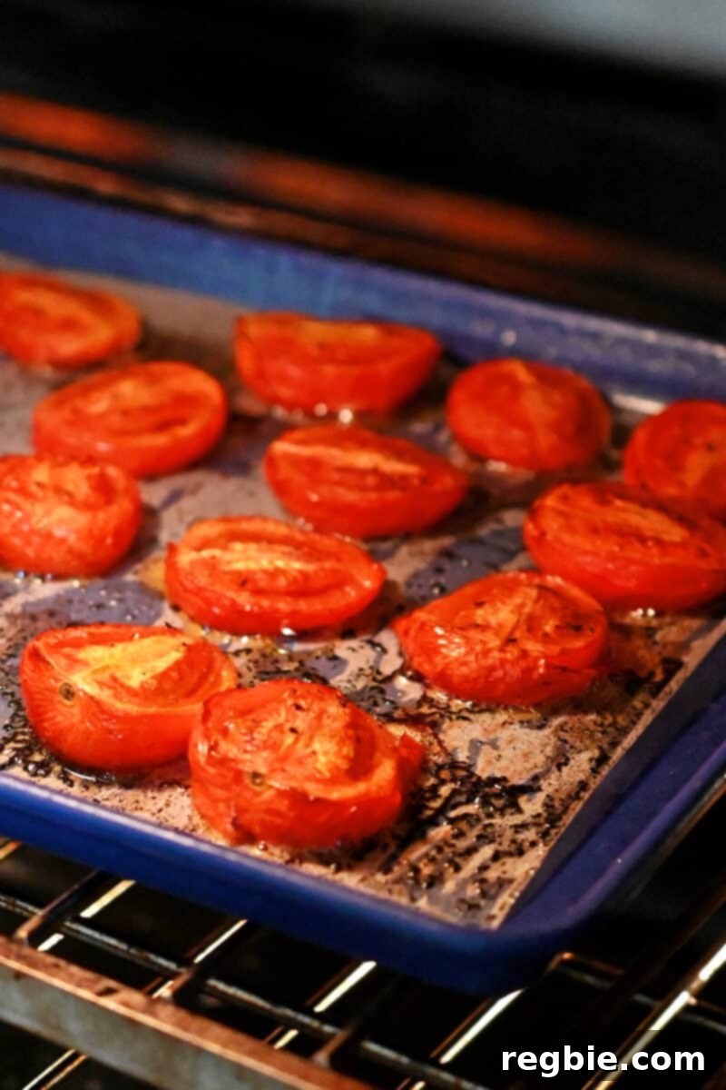 Umami-Packed Oven-Roasted Tomatoes: Easy, Whole30, Keto, Low Carb 9 An open oven with a tray of roasted tomatoes inside ready to be taken out.
