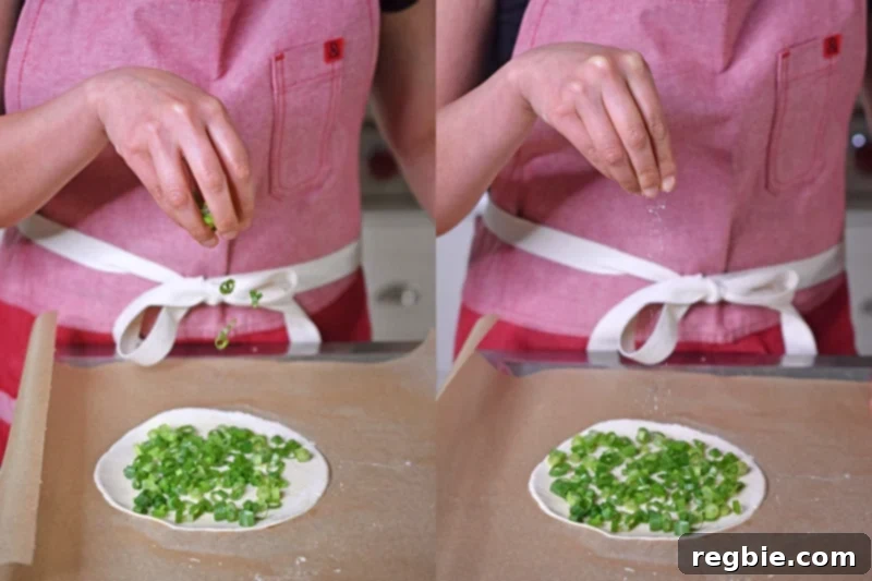 Sprinkling scallions and salt on a flattened piece of cassava flour dough to make Paleo Scallion Pancakes 