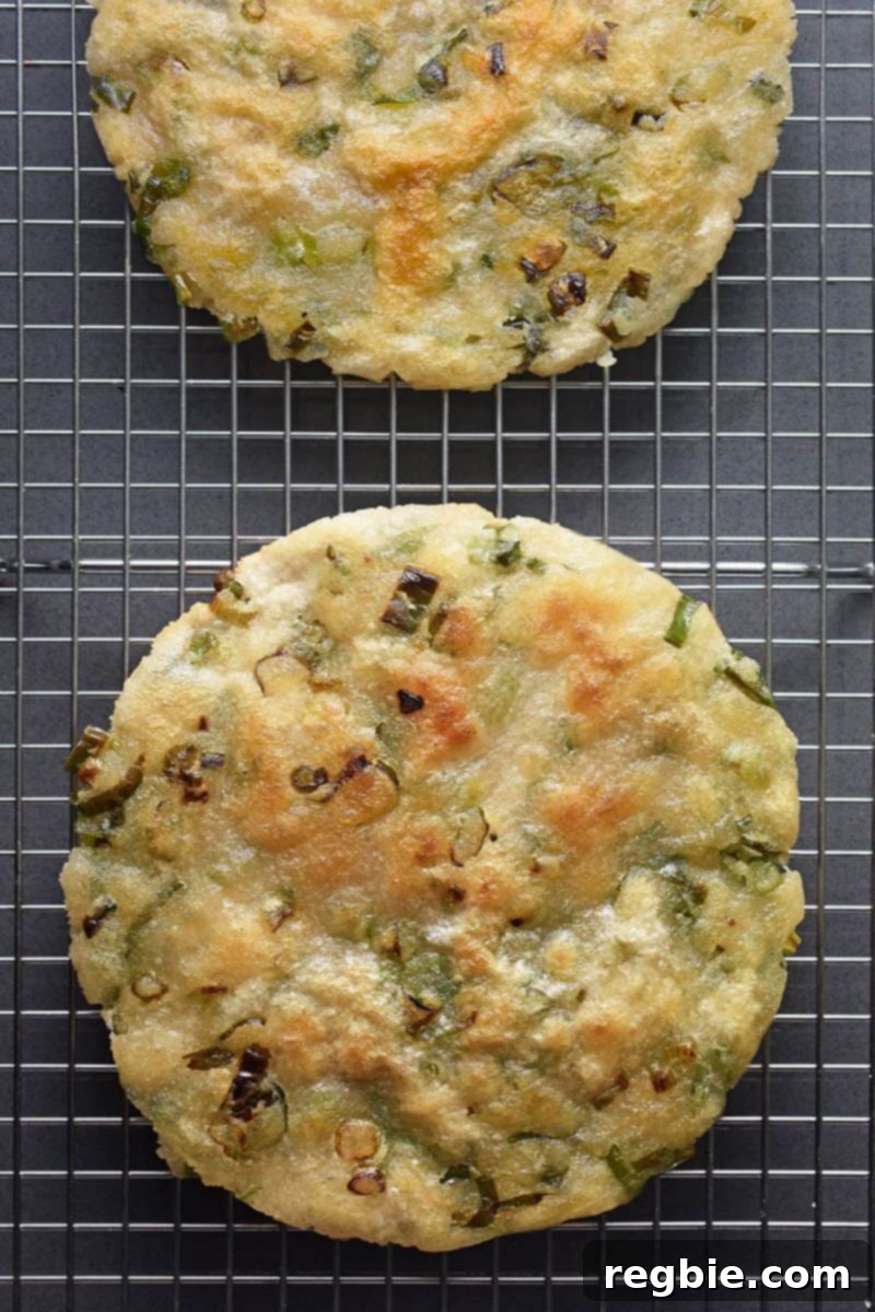 An overhead shot of two Paleo Scallion Pancakes on a wire cooling rack.