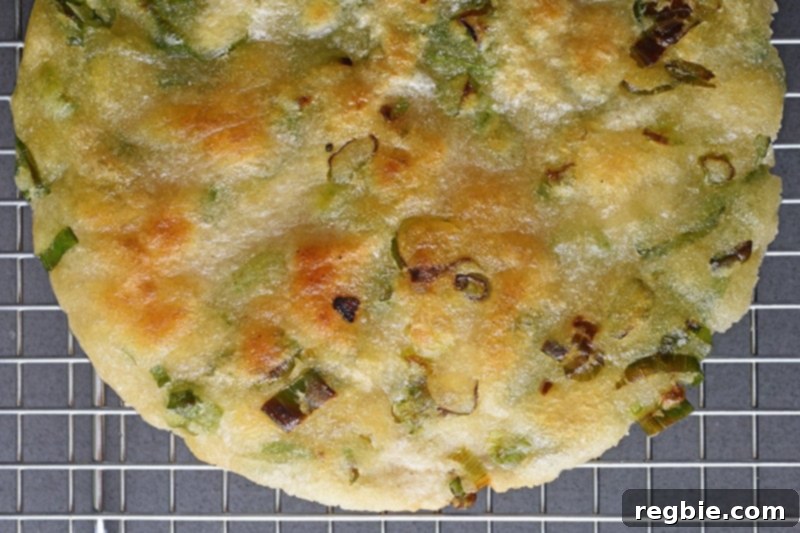 An overhead shot of a crispy Paleo and gluten-free Scallion Pancakes on a wire cooling rack.