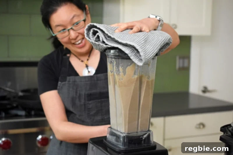 Blending the Instant Pot Cream of Mushroom Soup ingredients in a high speed blender.