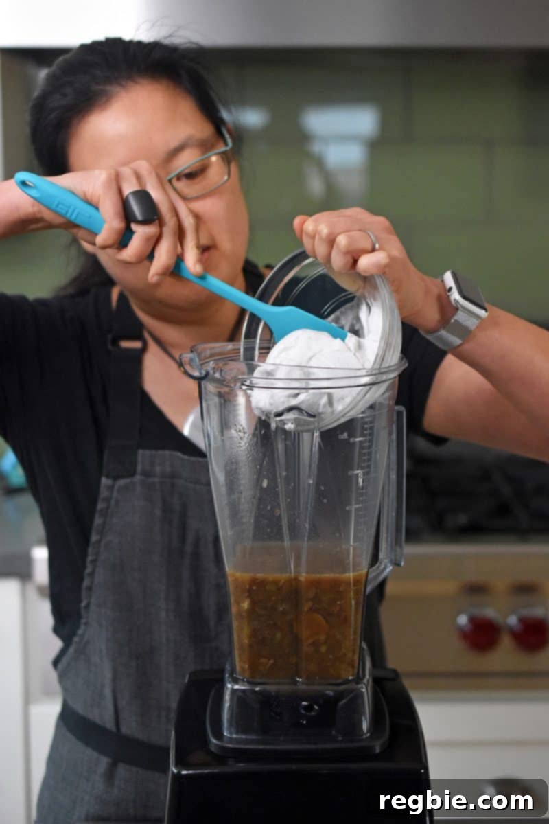 Adding coconut cream to the high speed blender.