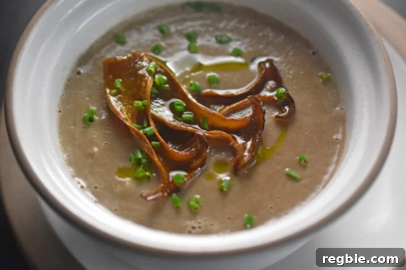 A bowl of Instant Pot cream of mushroom soup topped with mushroom chips.