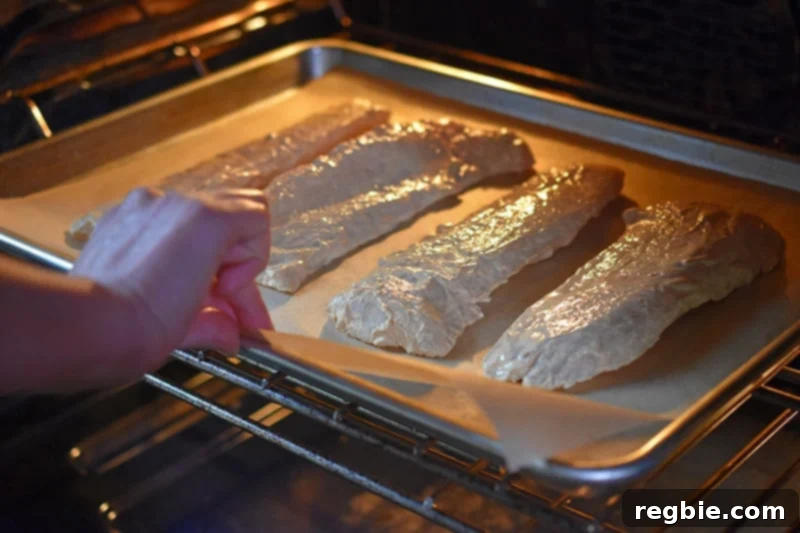 A tray of Tandoori Fish is carefully placed in the oven to bake until golden and cooked through.