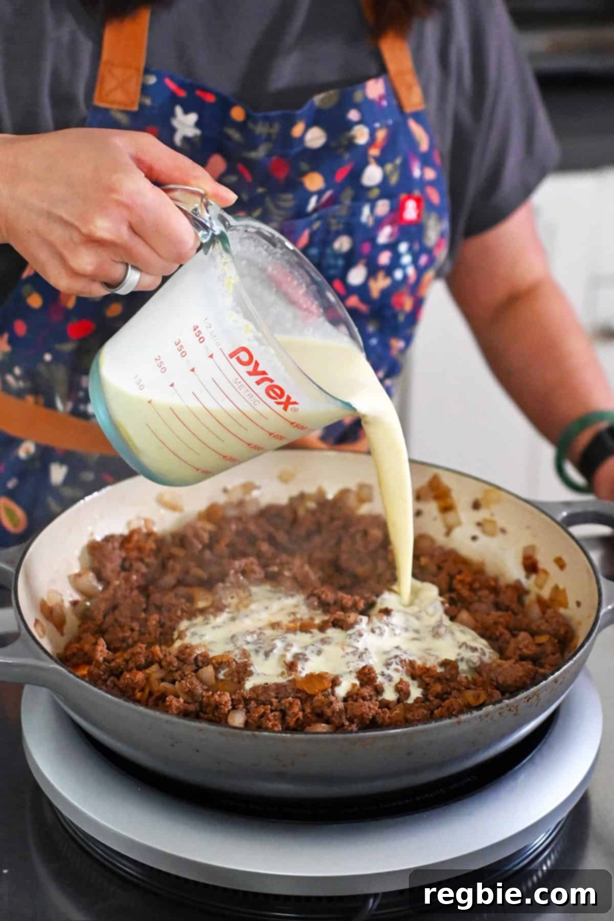 One-Pan Ground Beef and Veggie Power Bowl 10 Pouring sauce into skillet