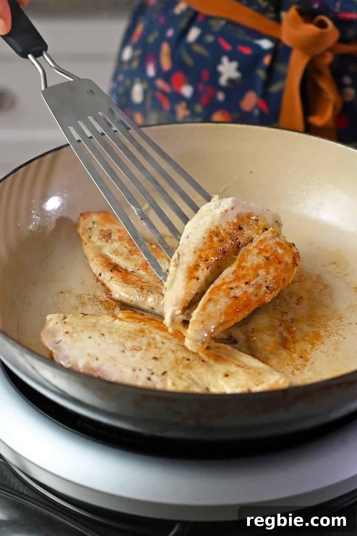 How I Cook Juicy, Tender Chicken Breasts Every Time 10 Flipping a boneless skinless chicken breast in a skillet with a fish spatula.