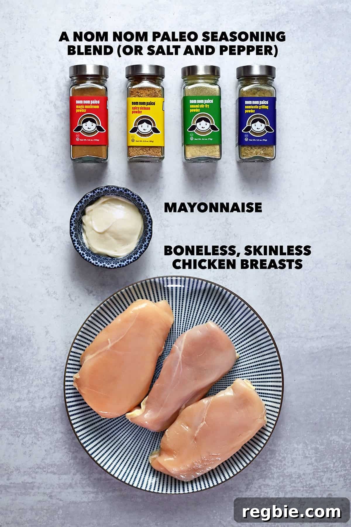 How I Cook Juicy, Tender Chicken Breasts Every Time 4 An overhead shot of the raw ingredients to make foolproof chicken breasts: boneless and skinless chicken breasts on a plate, Nom Nom Paleo seasoning blends, and some mayonnaise.